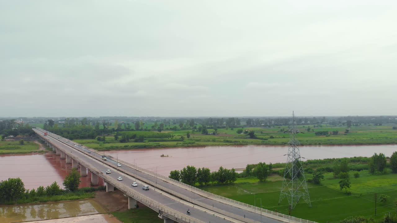 인도 펀자브 지역의 도시 외곽에 있는 비오는 진흙탕 물과 함께 비가 내린 후 강 근처의 농지 위로 날아가는 공중 전망과 운하