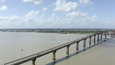 Toma-Aérea-De-Gran-Angular-Del-Puente-Jules-Wijdenbosch-Entre-Paramaribo-Y-Meerzorg-En-Surinam,-Sudamérica,-Con-Tráfico-Mientras-Un-Dron-Vuela-Sobre-El-Puente.