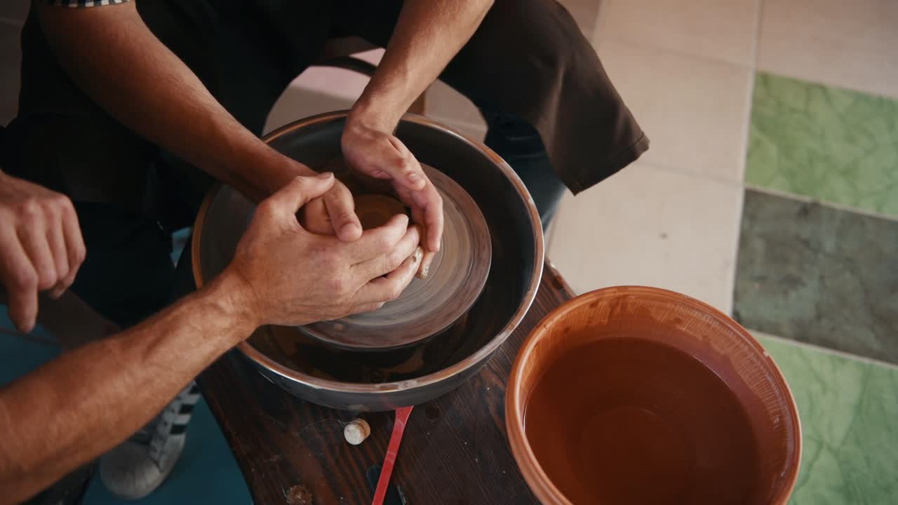 viejo tipo experimentado enseñar al hombre cómo usar la rueda de alfarero para crear producto de arcilla hecho a mano