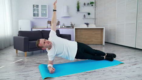 fit man in t-shirt doing exervises. healthy athletic man training in home.