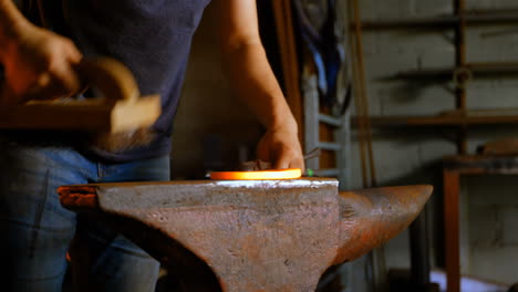 metalsmith  brushing horseshoe in fire 4k