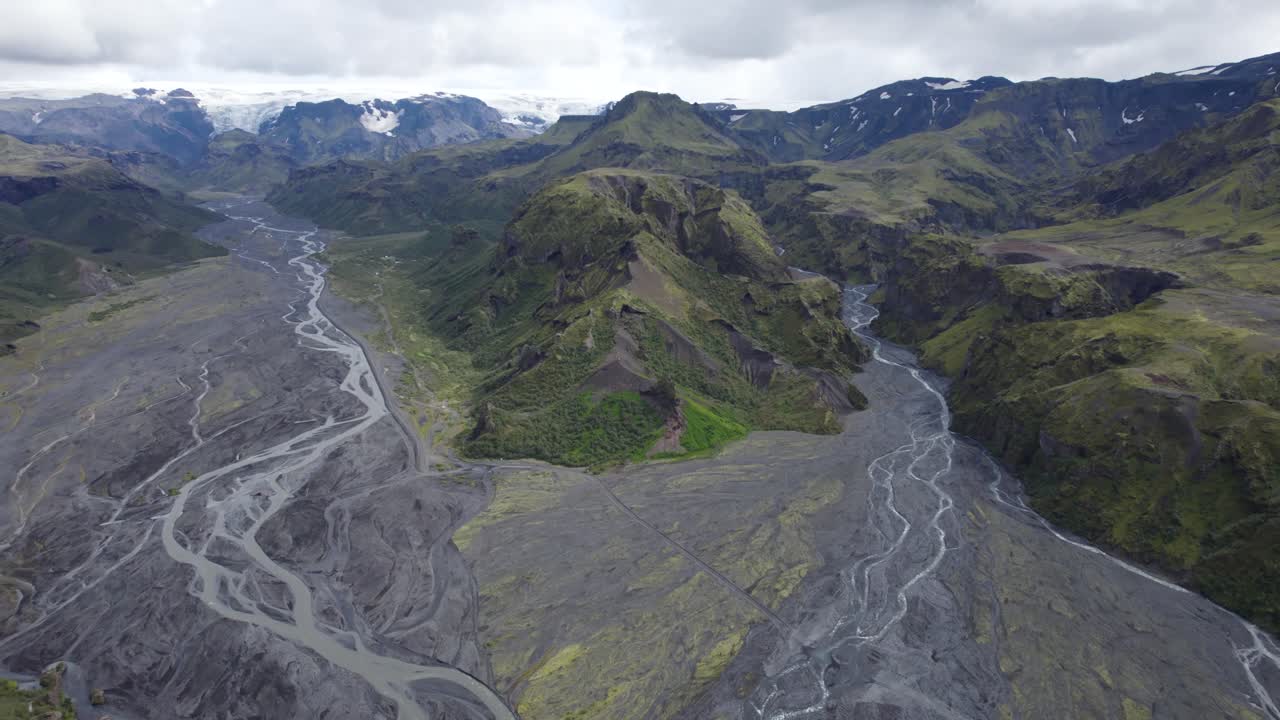 retirada aérea por encima de la corriente glacial en thorsmork, islandia, con valles verdes