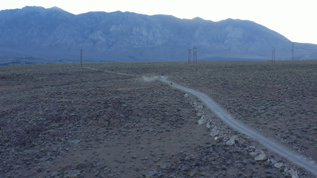 아름다운 산을 배경으로 캘리포니아주 비숍의 계곡을 가로지르는 자전거 타는 사람의 공중 전망