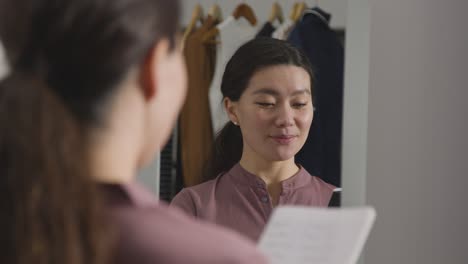 Young-Woman-In-Home-Practising-Job-Interview-Technique-Reflected-In-Mirror-2