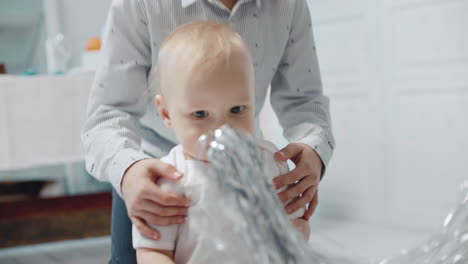 zwei wunderschöne geschwister, die vor der kamera schauen. hübscher kleiner junge, der lametta spielt