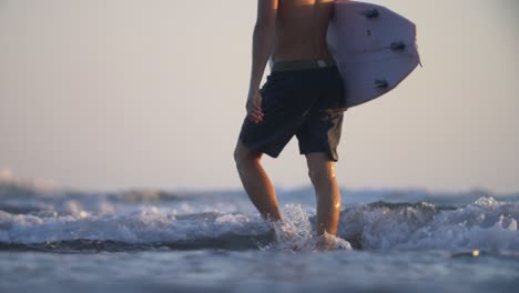 focus pull of a man carrying a surfboard