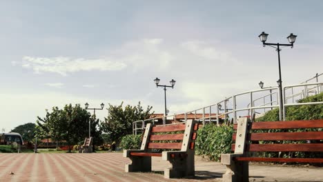 Timelapse-of-public-park-with-beautiful-vegetation,-street-lamps,-benches-and-a-clear-blue-sky-during-a-hot-sunny-morning-at-Panama-CIty's-Causeway-of-Amador