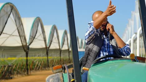 man sitting tractor and talking on mobile phone 4k