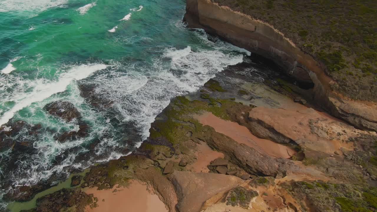 4k Aerial rocky beach near cliff with blue water Drone jib down shot