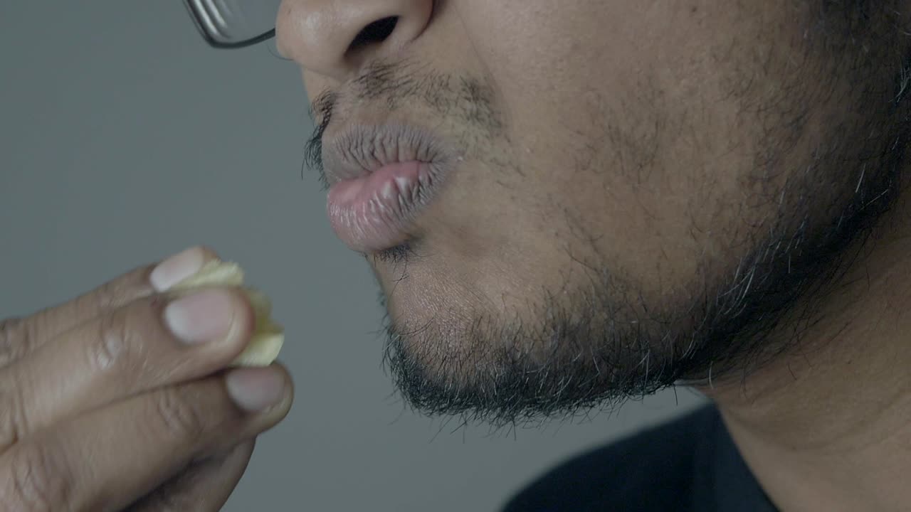 Close-up of Man Eating a Handful of French Fries