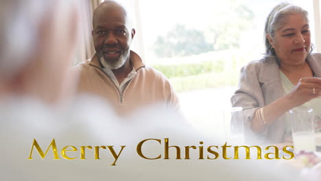 animación de texto de feliz navidad sobre diversos amigos mayores en la cena de navidad en casa