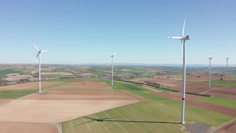 Planta-De-Energía-Eólica-Giratoria-Que-Produce-Electricidad-De-Energía-Limpia-Verde-Renovable-En-Un-Parque-Eólico-En-Un-Día-Soleado,-Tiro-Panorámico-Giratorio-Aéreo-De-Drones,-25p