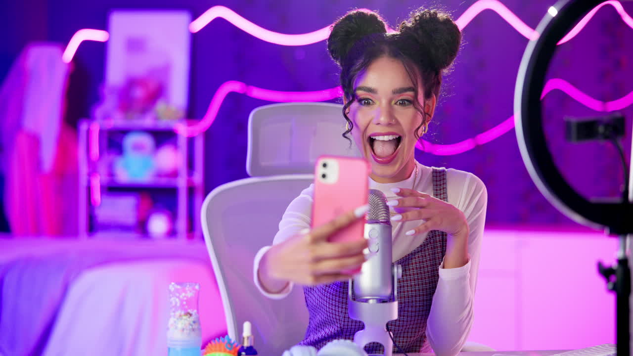 Woman taking selfies in her bedroom with ring light and microphone