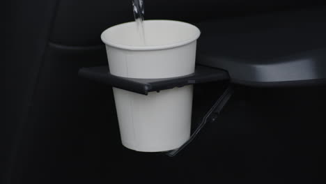 Close-up-travel-cupholder-being-filled-with-water