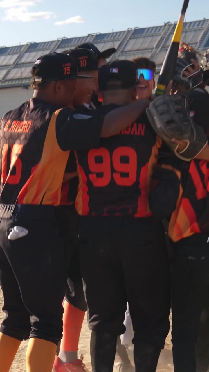 Squadra giovanile di baseball che celebra la vittoria sul campo.
