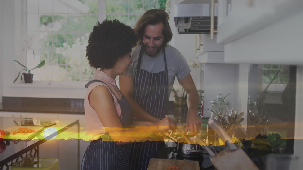 In kitchen, couple cooking together with sunset animation overlay in background
