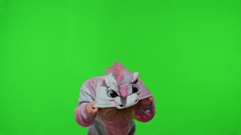 Child-girl-in-unicorn-pajamas-making-silly-funny-faces,-fooling-around,-showing-tongue-on-chroma-key