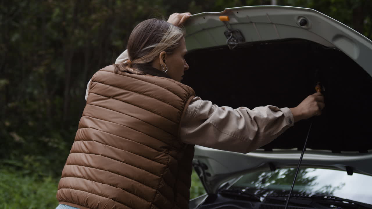 Woman Inspecting Car Engine