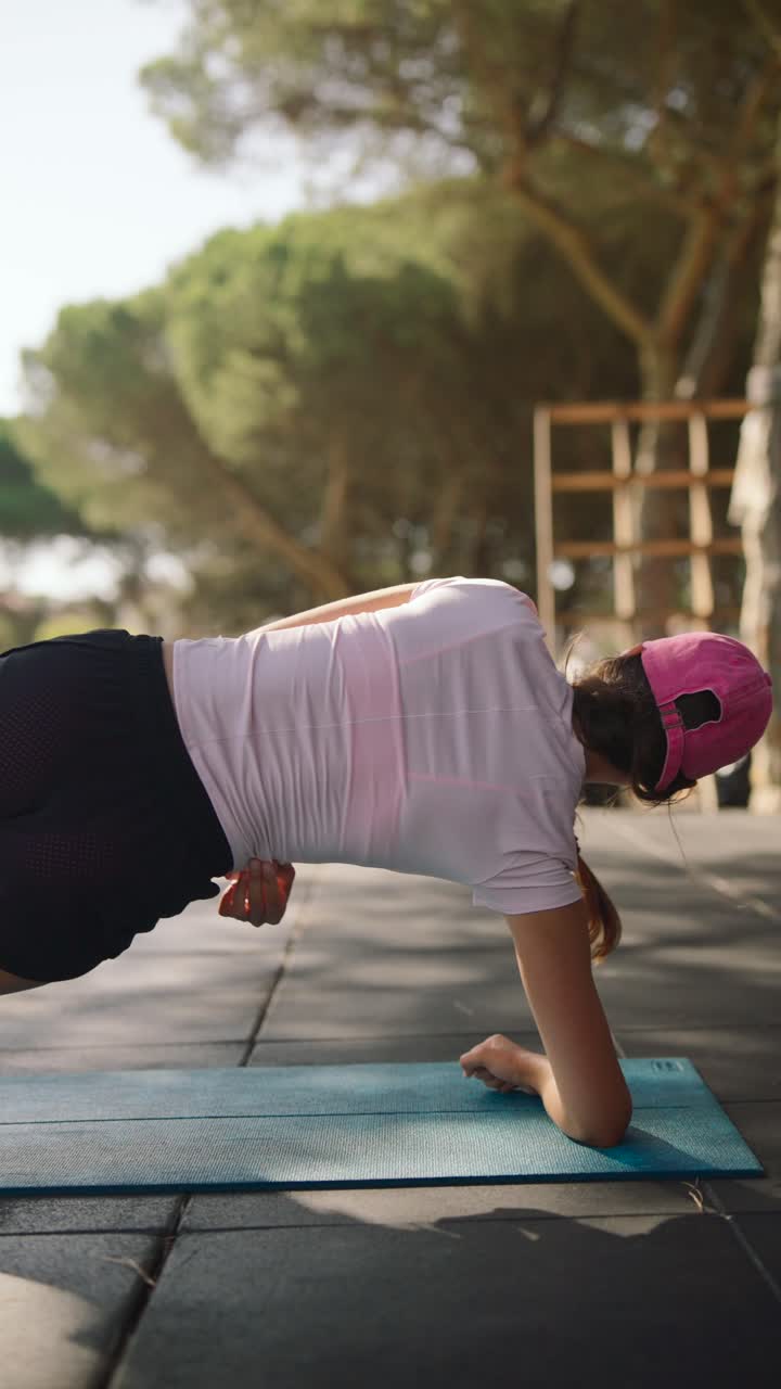 mujer haciendo un ejercicio de tabla al aire libre