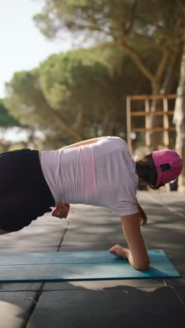 mujer haciendo un ejercicio de tabla al aire libre