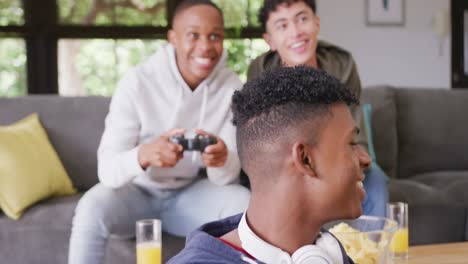 happy diverse male teenage friends playing video games at home, slow motion