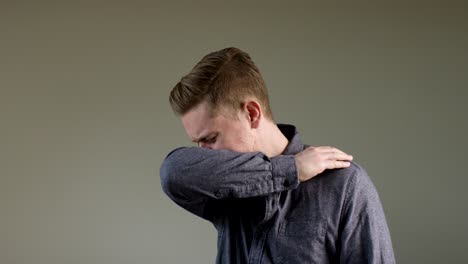 european man coughs into arm in slow motion a