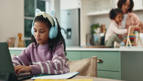 young girl concentrating on her homework with her family in the background