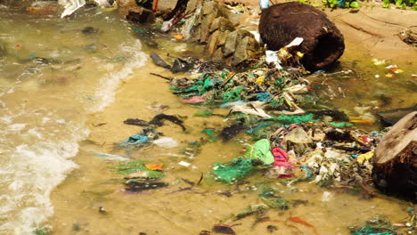 water pollution, dirty sea shore with floating plastic trash, microplastics and waste close up