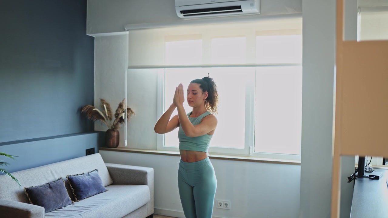 Giovane donna che pratica yoga e stretching in soggiorno