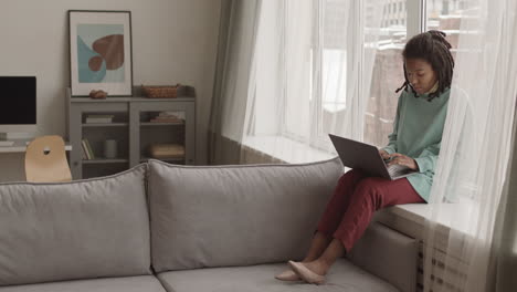 beautiful african woman using laptop at home