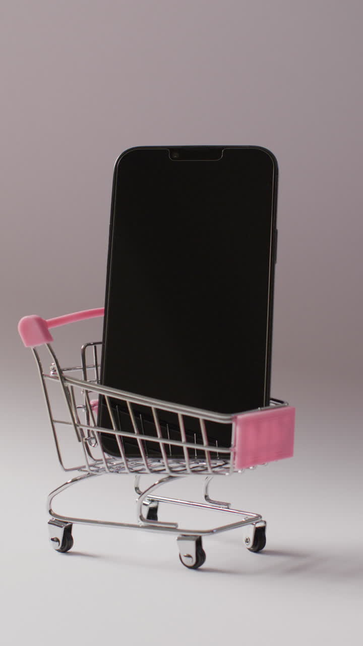 video vertical del carrito de compras con teléfono inteligente en fondo gris