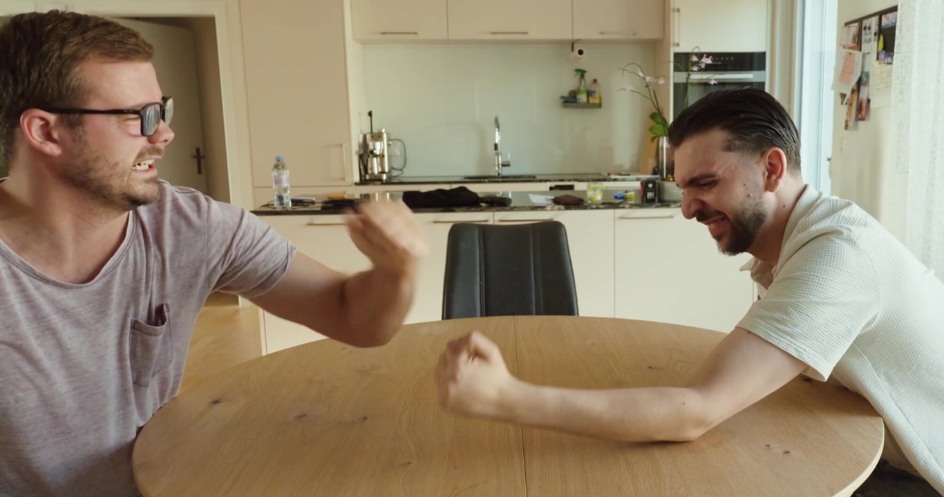 Two men compete in an arm wrestling match across a table. Concept of strength, competition, determination, and friendly rivalry.
