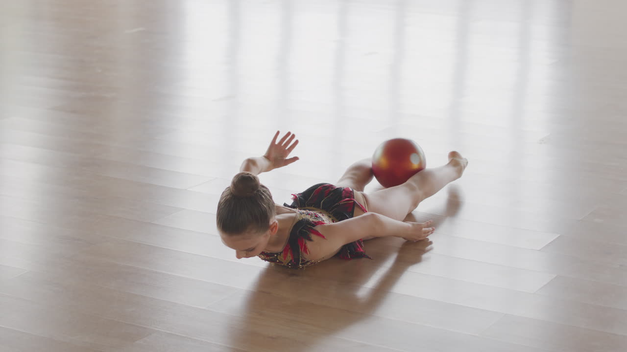 Young Girl In Leotard Practising Rhythmic Gymnastic With A Ball In A Studio 3