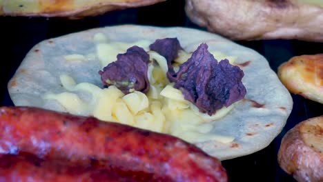 primer plano de carne asada con chorizos, tortillas de queso, frijoles guatemaltecos y patatas asadas fumando y preparación jugosa lista para comer tiempo de fusión [hd1920 x 1080] fps 29