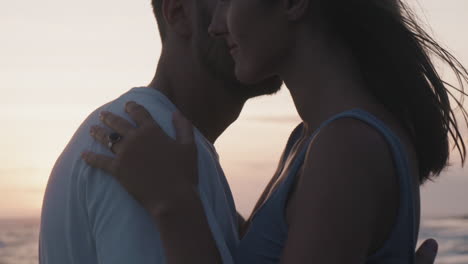 man and woman kissing on sunset