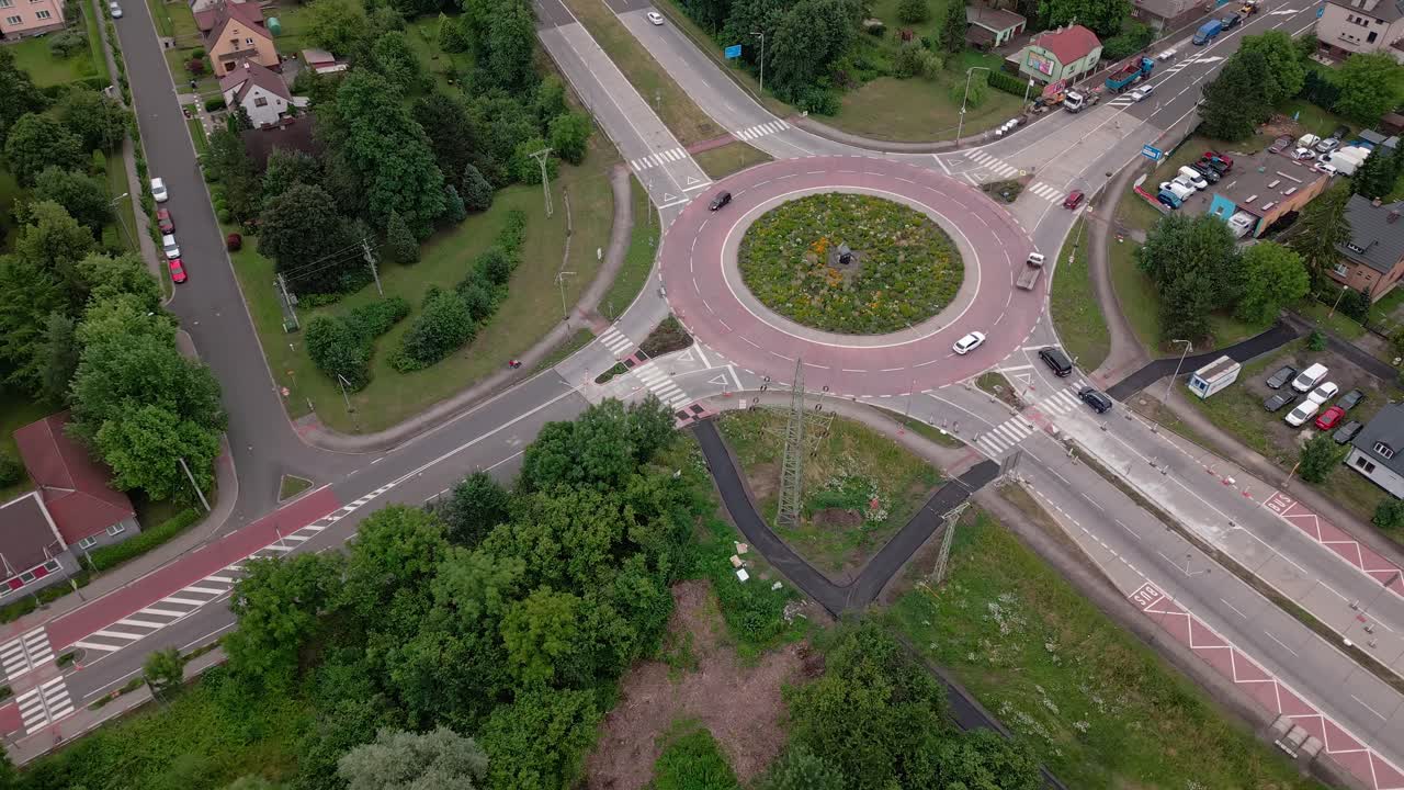 Cars navigate urban gyratory roundabout traffic flow system AERIAL