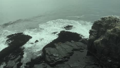 aerial going forward among rocky formations on a dark day, pichilemu, chile-4k