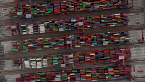 Ascending-aerial-overhead-view-of-automated-cranes-moving-large-shipping-cargo-containers-in-Hamburg-port