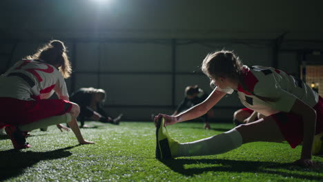 women's soccer team stretching on a field