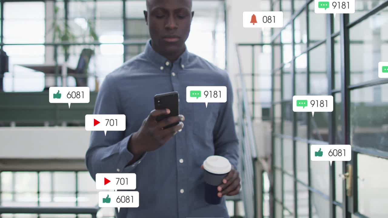 Animation of social media icons on african american man drinking coffee using smartphone at office