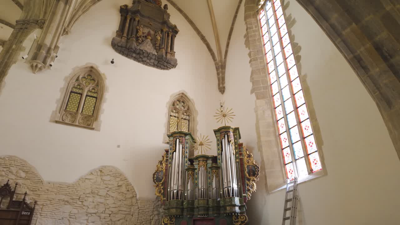 Pan down to the historic organ within the Lutheran Cathedral of Saint Mary, emphasizing its cultural and architectural significance