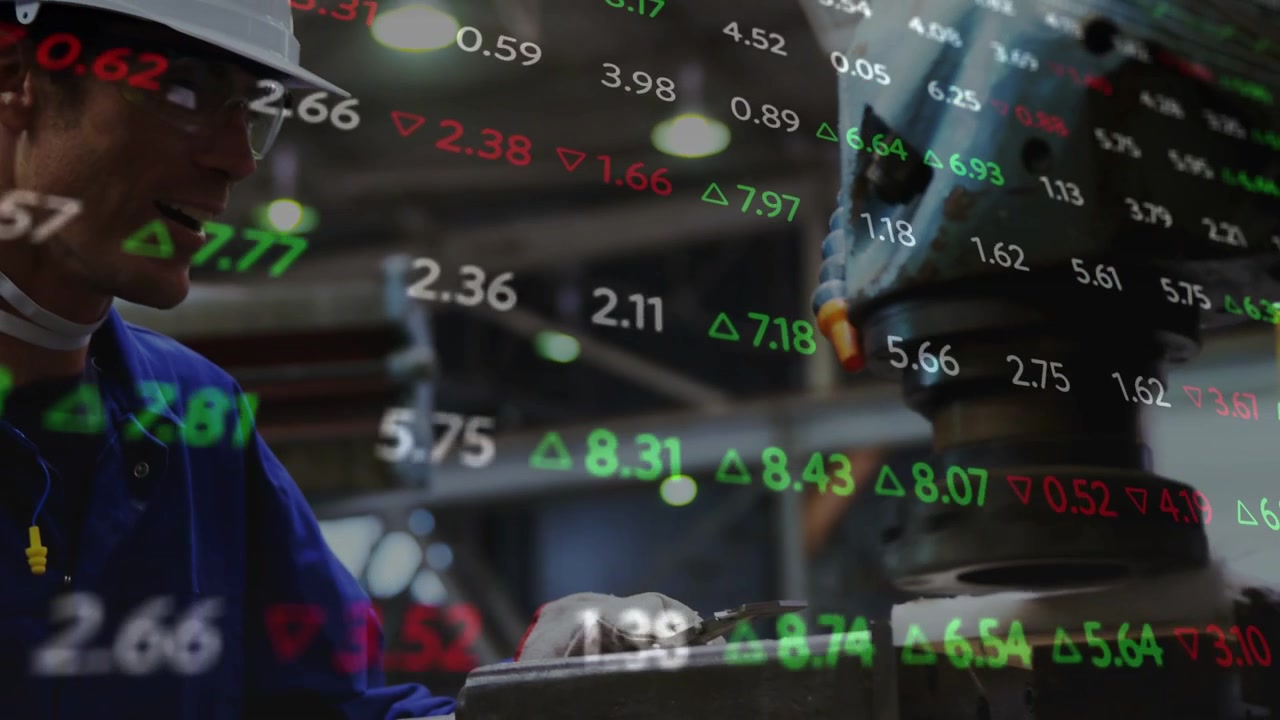 Maskinist justerar klämma, sänker spindel, spetsen fäster vid delen, finansiella tickers överlagrar scenen.