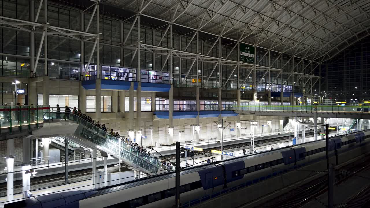 Modern Train Station at Night with Train and People