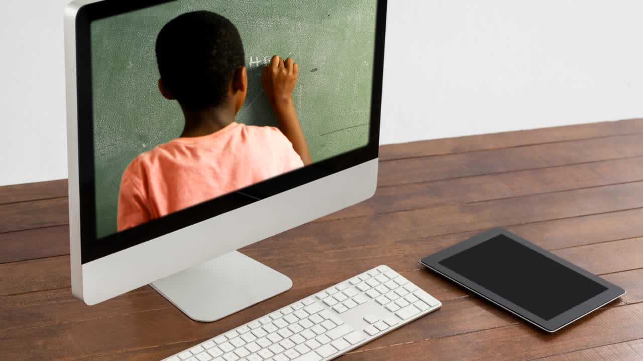 Animation of a computer monitor showing a biracial boy writing on a blackboard