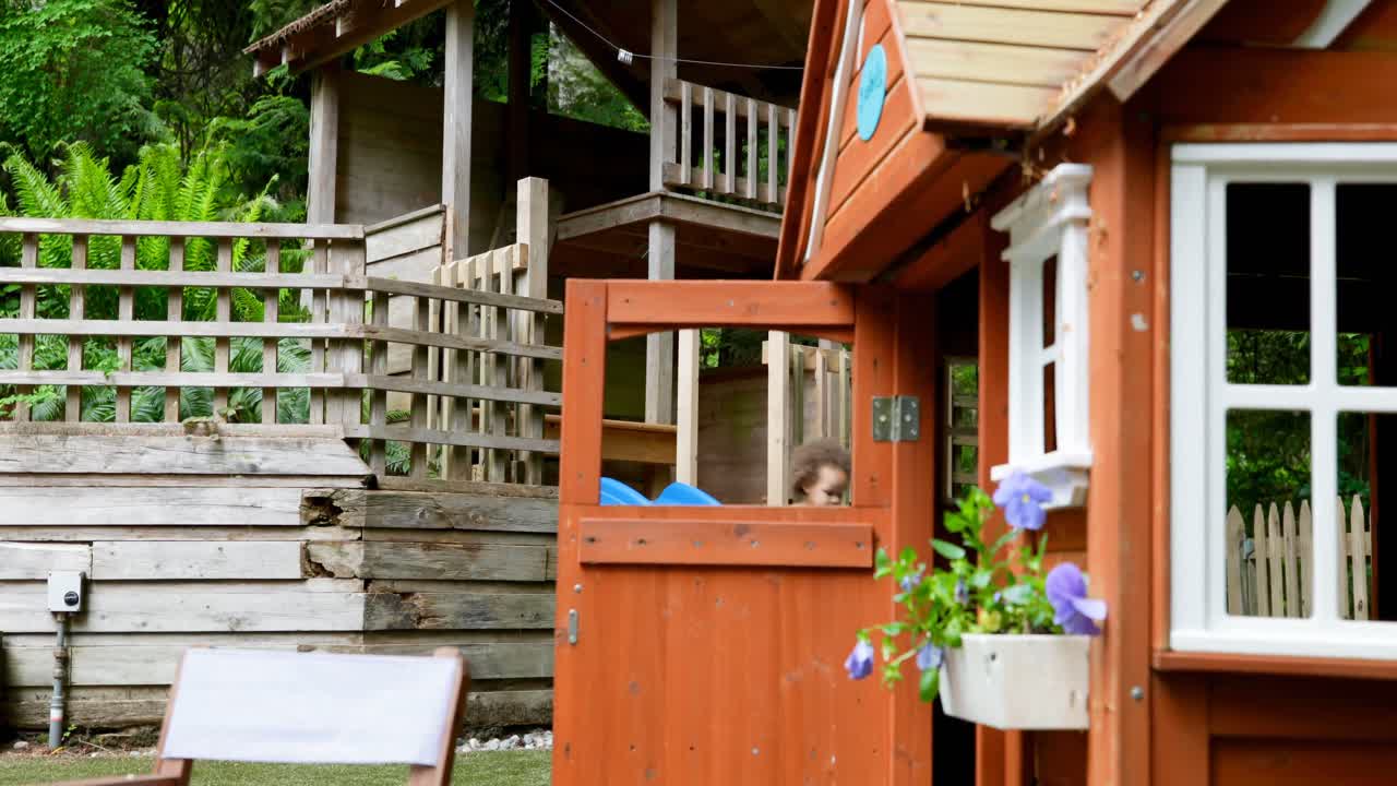 뒷마당 4k에서 슬라이드에서 놀고 있는 아기 소녀