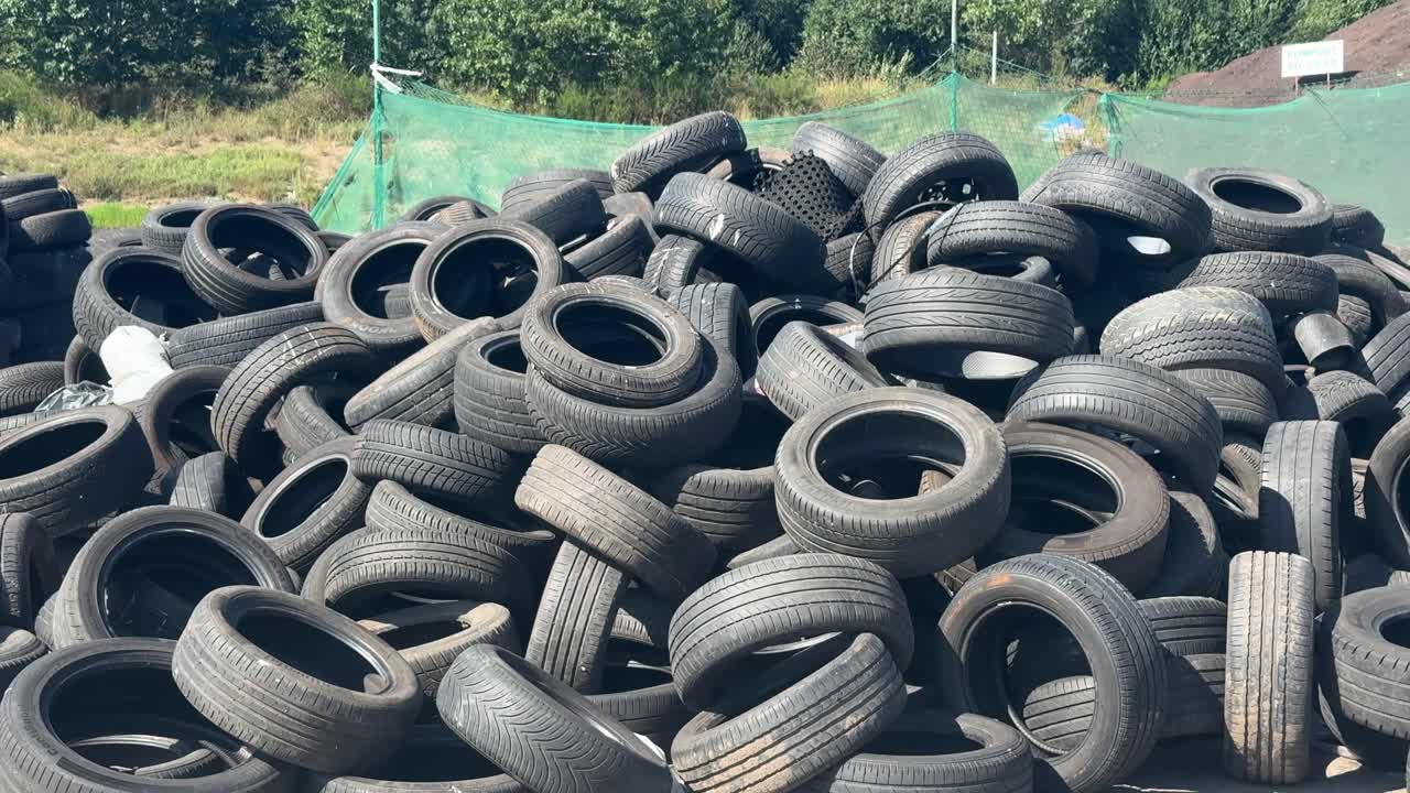 Pile of used car tyres at waste disposal site. Climate impact of automotive industry