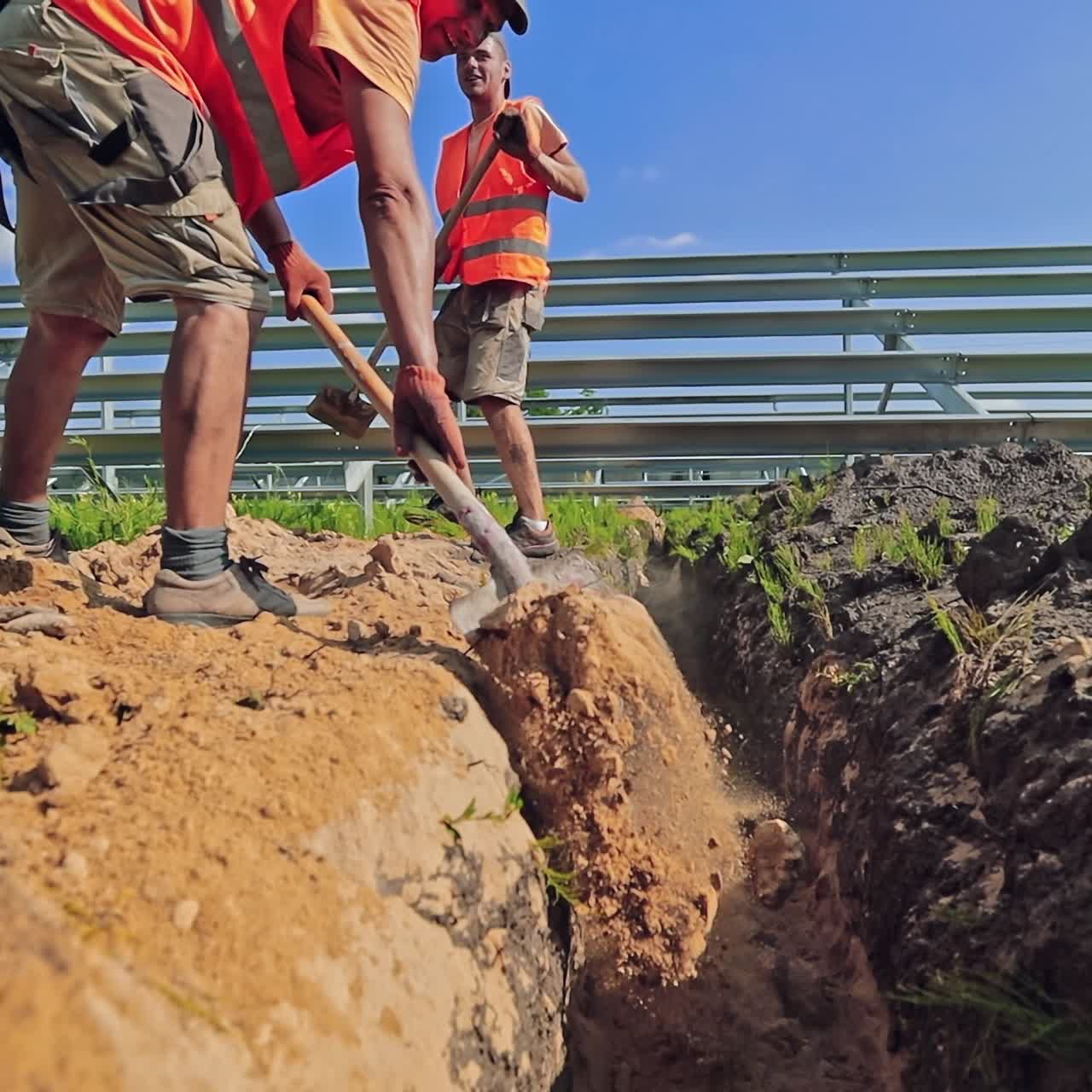 Workers men build the solar farm on the field. Engineers prepare the ground for construction of future power plant. Renewable energy.