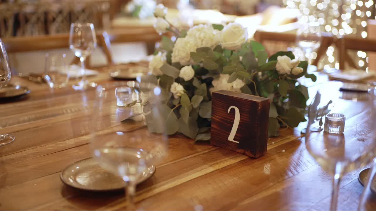 Rustic wedding table with floral centerpiece and wooden number sign