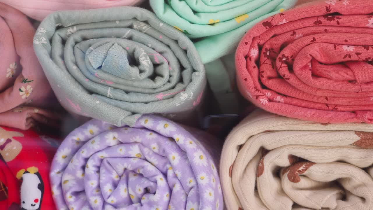 Collection of Rolled Colorful Fabrics with Various Patterns