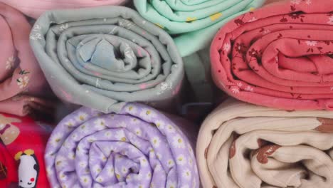 collection of rolled colorful fabrics with various patterns